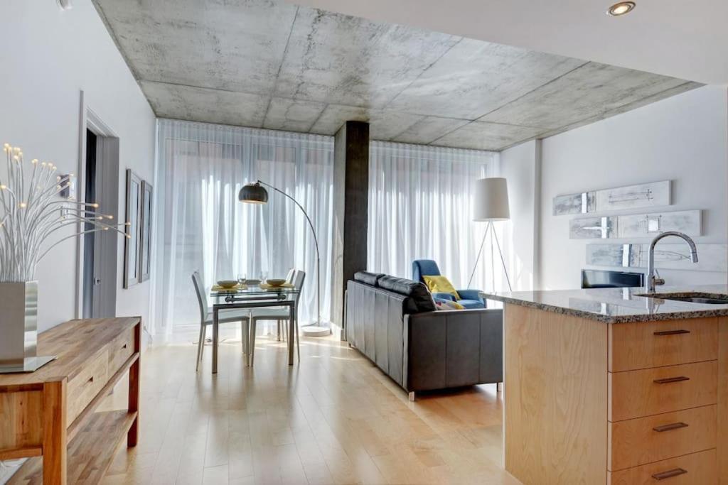 eine Küche und ein Wohnzimmer mit einem Sofa und einem Tisch in der Unterkunft Les Immeubles Charlevoix - 760-307 in Québec