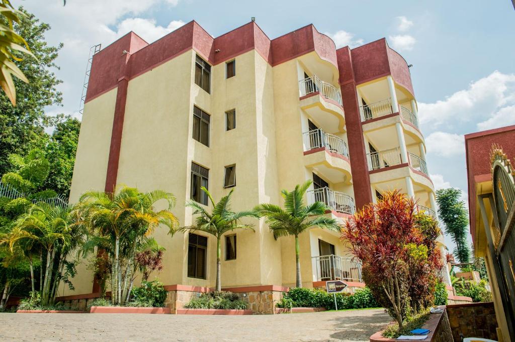 a building with palm trees in front of it at Rohi Apartments in Kigali