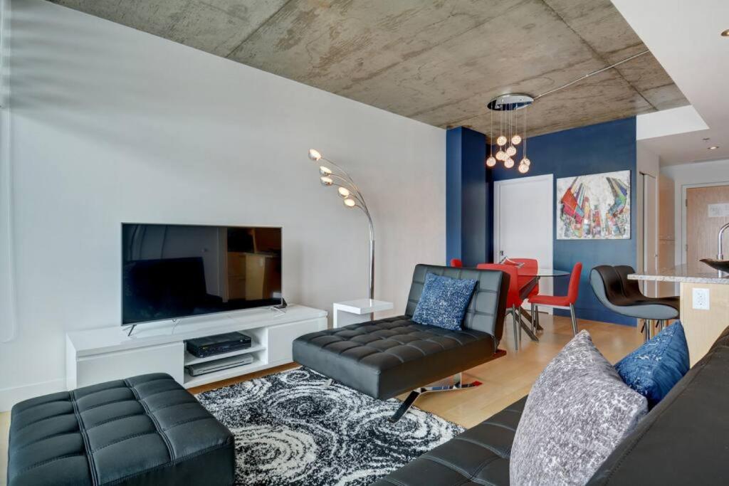 uma sala de estar com um sofá e uma televisão em Les Immeubles Charlevoix - 760-505 em Quebeque