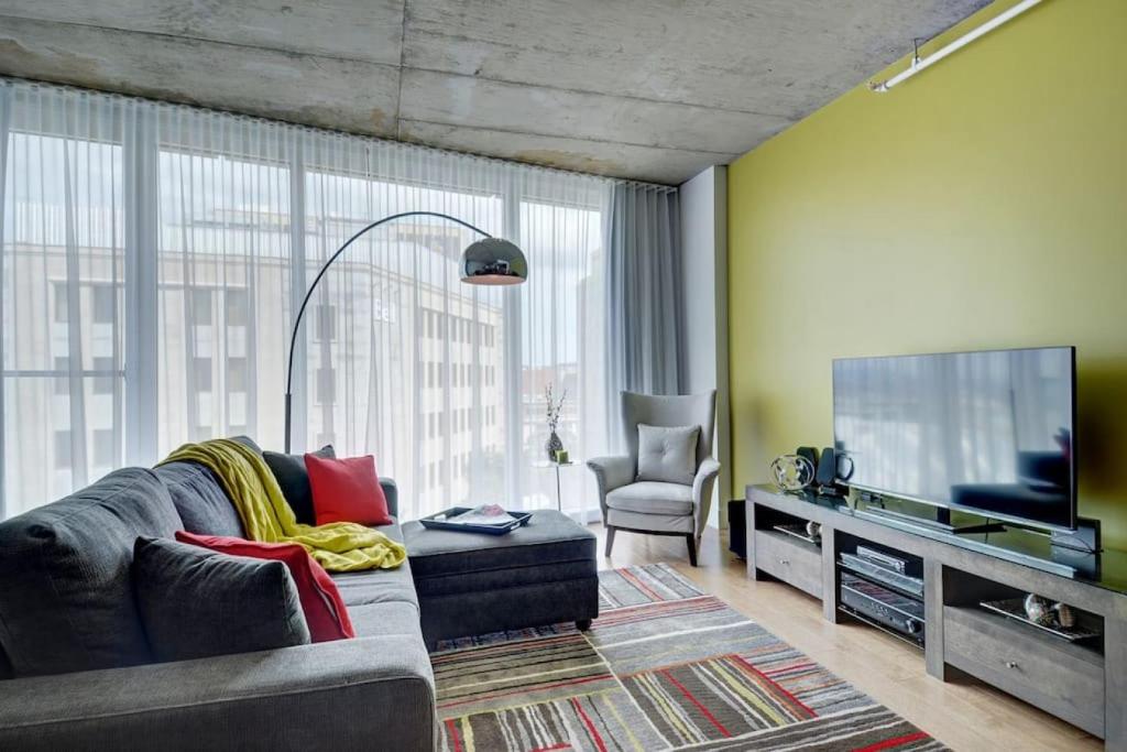 uma sala de estar com um sofá e uma televisão de ecrã plano em Les Immeubles Charlevoix - 760-510 em Cidade de Quebec