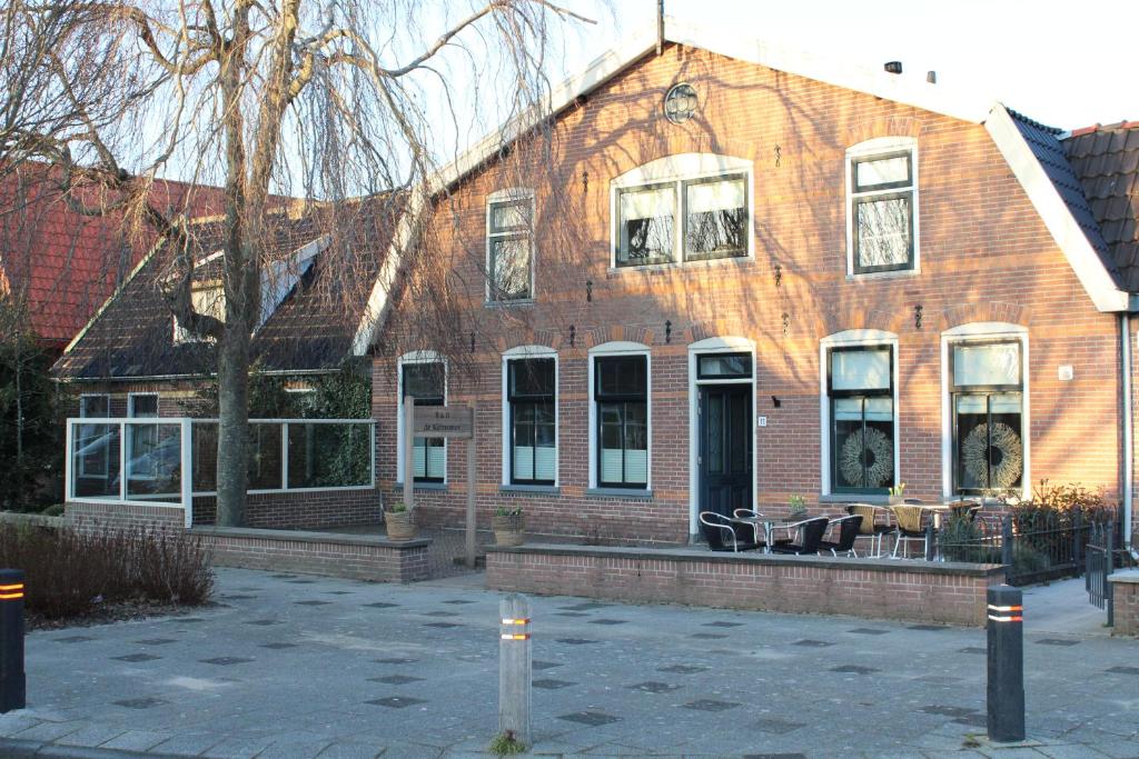 a large brick building with a patio in front of it at B&B de Keinsmer in 't Zand
