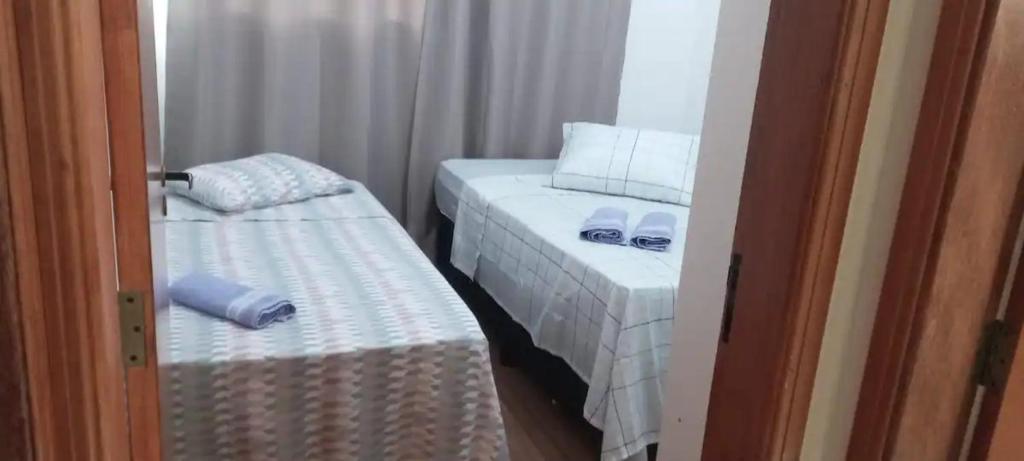 ein kleines Zimmer mit 2 Betten und einem Fenster in der Unterkunft Ap dos sonhos 2 in Poços de Caldas