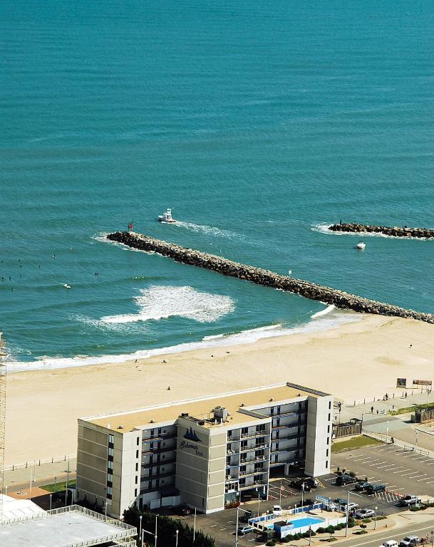 a view of a beach with a building and the ocean at The Schooner Inn in Virginia Beach