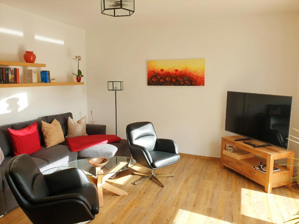 a living room with a couch and chairs and a television at Ferienwohnung Zur Flatter-Ulme in Weißwasser