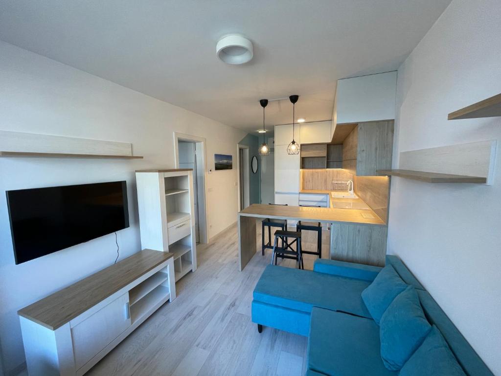 Il comprend un salon avec un canapé bleu et une cuisine. dans l'établissement Modern and quiet apartment with air conditioning and free parking, à Košice