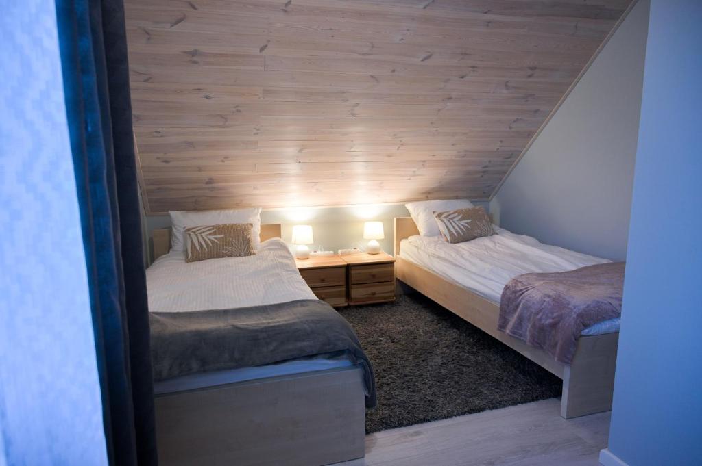 a bedroom with two beds and a table with lamps at Apartament u Sikorki in Ustrzyki Dolne