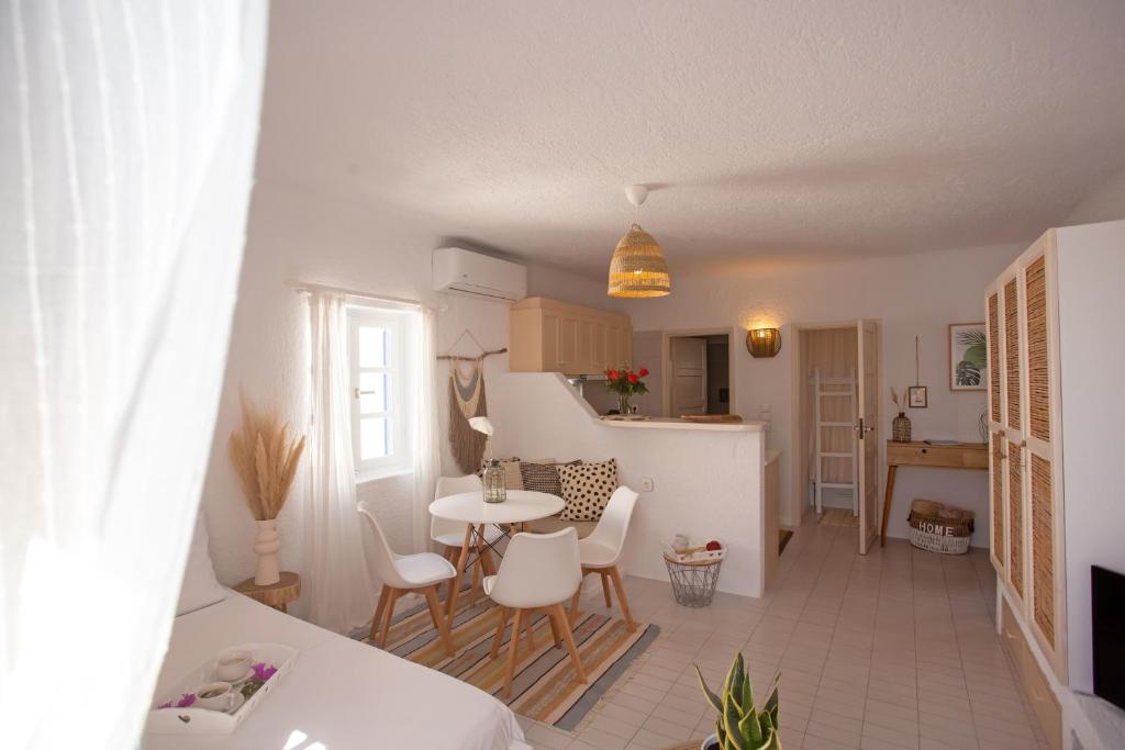 a kitchen and a living room with a table and chairs at Hidden Serenity in Mikonos