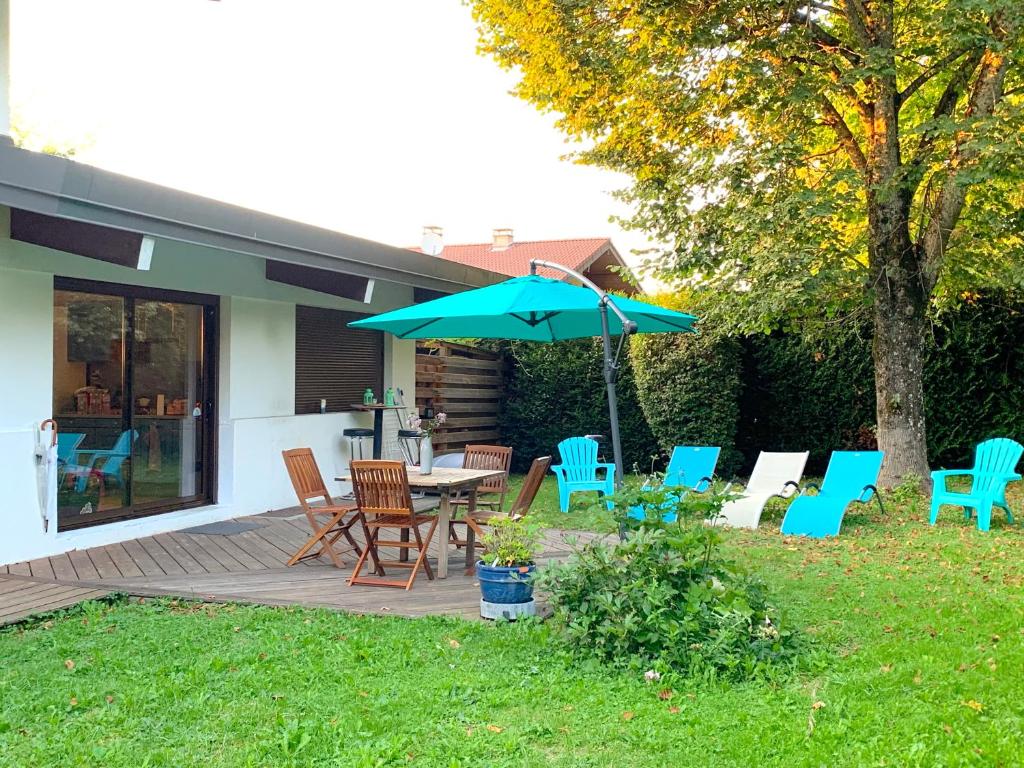 un patio avec une table, des chaises et un parasol dans l'établissement Chez-luc, à Allinges