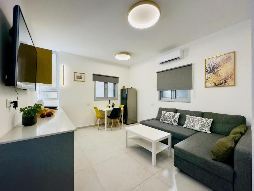 a living room with a couch and a table at Amazing 2Rooms Apt in Bat Yam - Step by the beach in Bat Yam