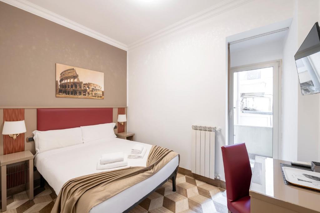 a bedroom with a bed and a desk and a window at The Five Oscars Inn in Rome