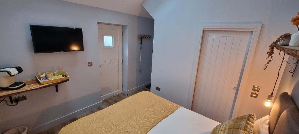a bedroom with a bed and a television on the wall at Ring O Bells Hinton Blewett in Bristol