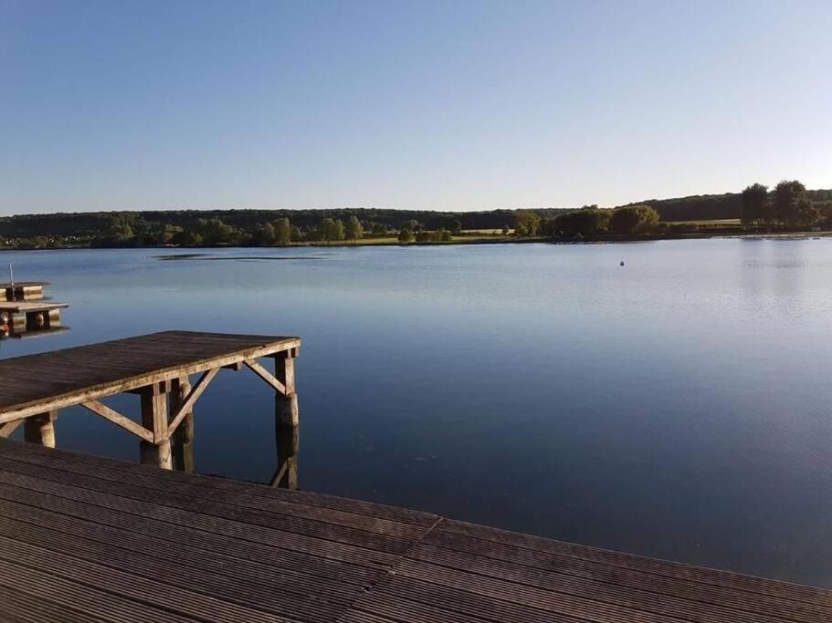 a view of a large lake with a dock at maison nature spéciale JO 2024 in Savignies