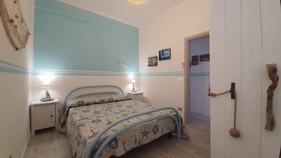 ein Schlafzimmer mit einem Bett und zwei Tischen mit Lampen in der Unterkunft casa vacanza fronte mare Fano Sassonia 2 in Fano