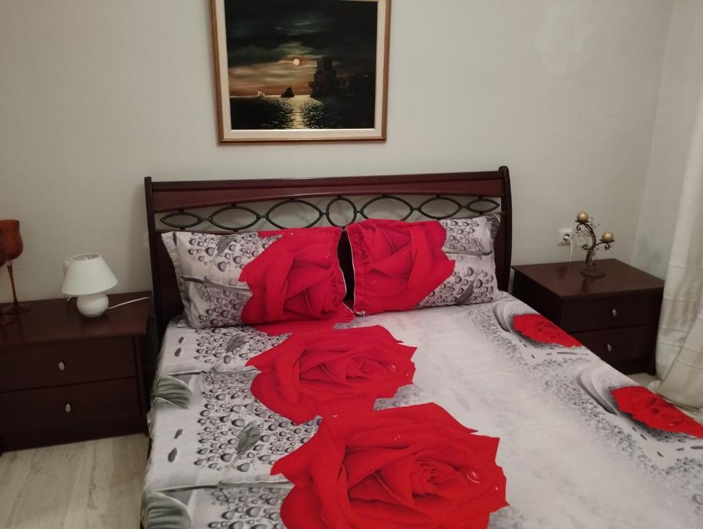 un lit avec trois roses rouges sur lui dans l'établissement MARIOS HOUSE 1, à Xánthi