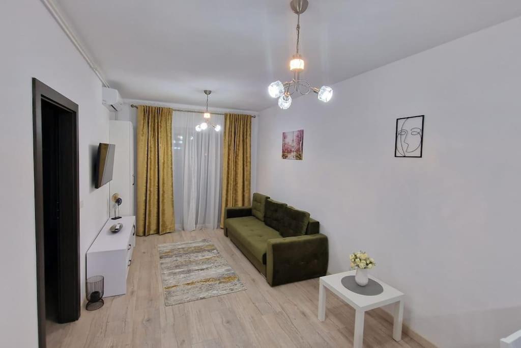 a living room with a green couch and a table at Apartament Adora Alex in Arad