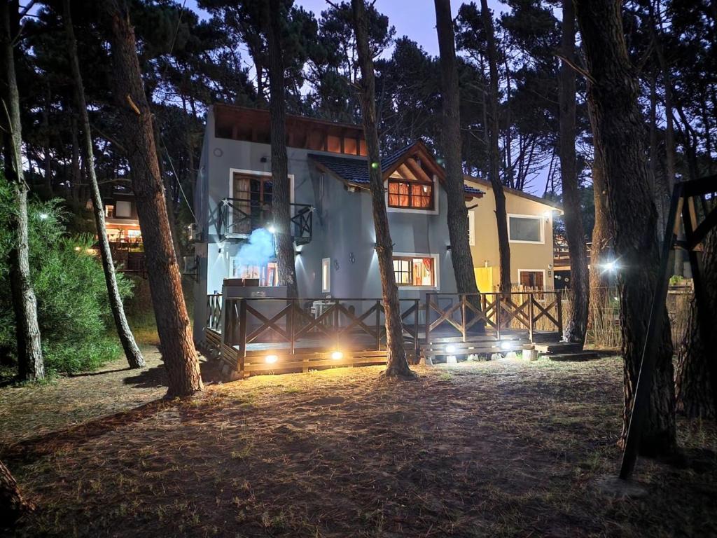 uma casa com luzes na floresta à noite em Sueños de Mar em Mar Azul