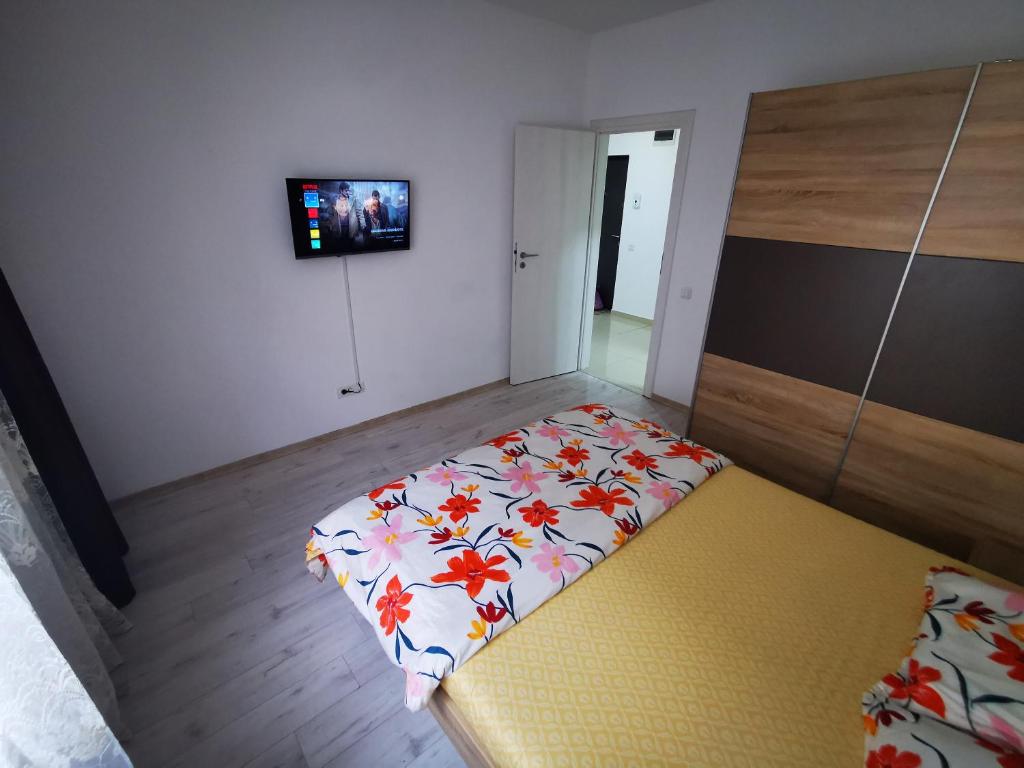 een kamer met een bed met een bloemendeken erop bij Two Bedroom Apartment in Roşu