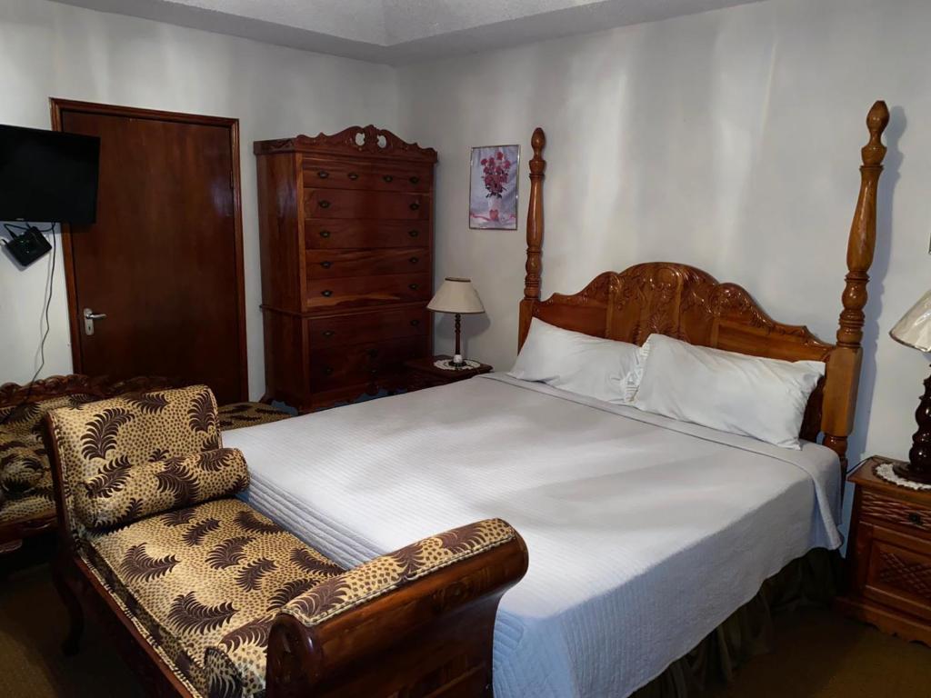 sypialnia z dużym łóżkiem i krzesłem w obiekcie Home away from home w mieście Mandeville