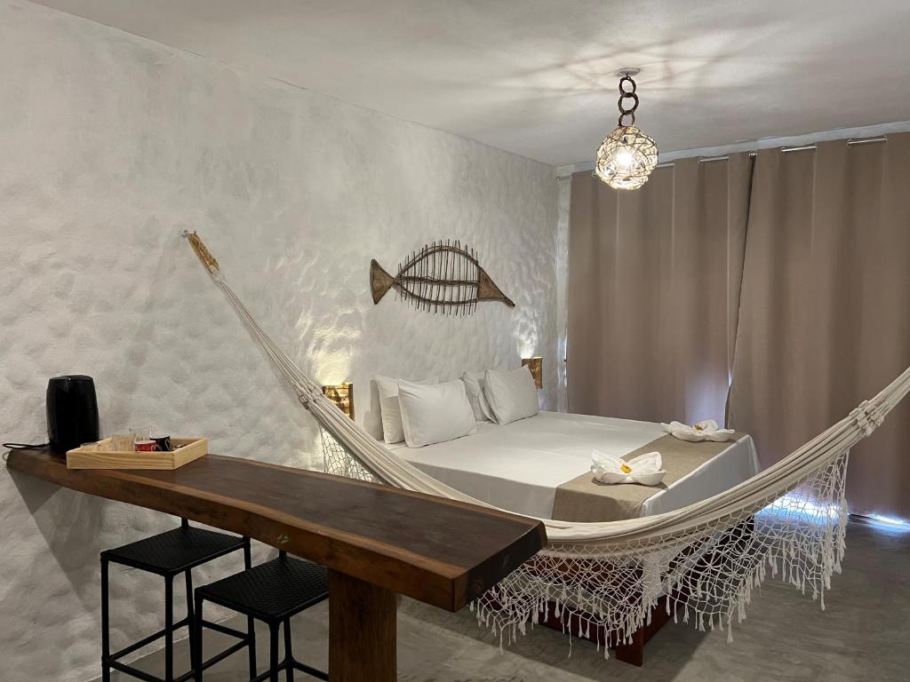 Casa di Maria flats في إيكاري: غرفة نوم مع سرير أرجوحة وطاولة