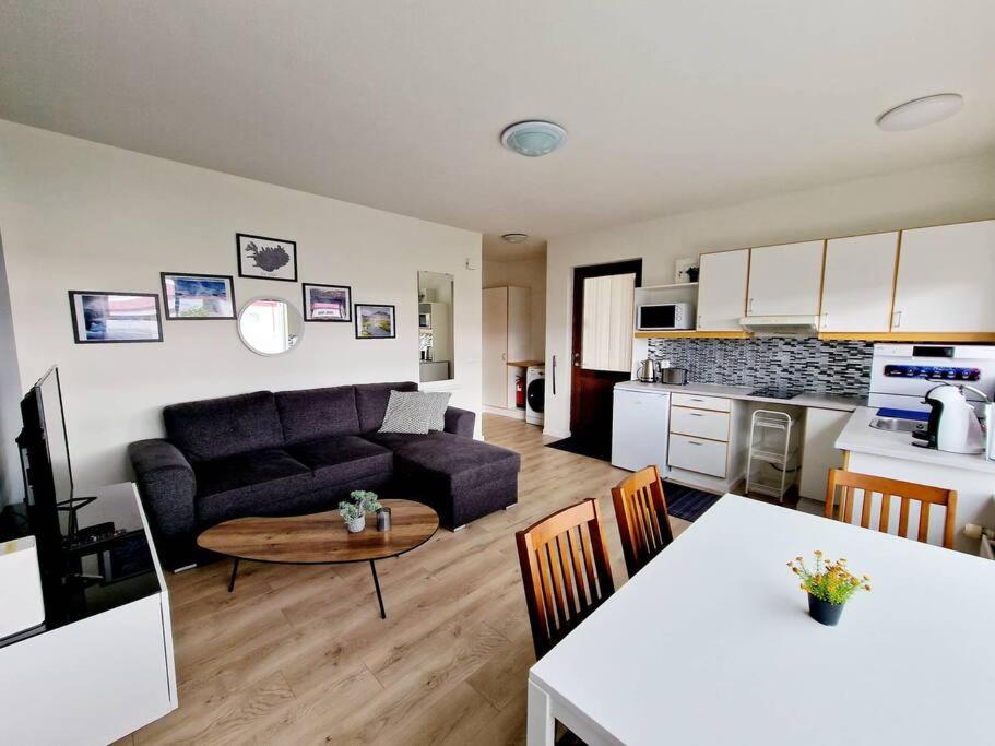 uma sala de estar e cozinha com um sofá e uma mesa em Wonderful apartment with beautiful natural pearls. em Bifrost