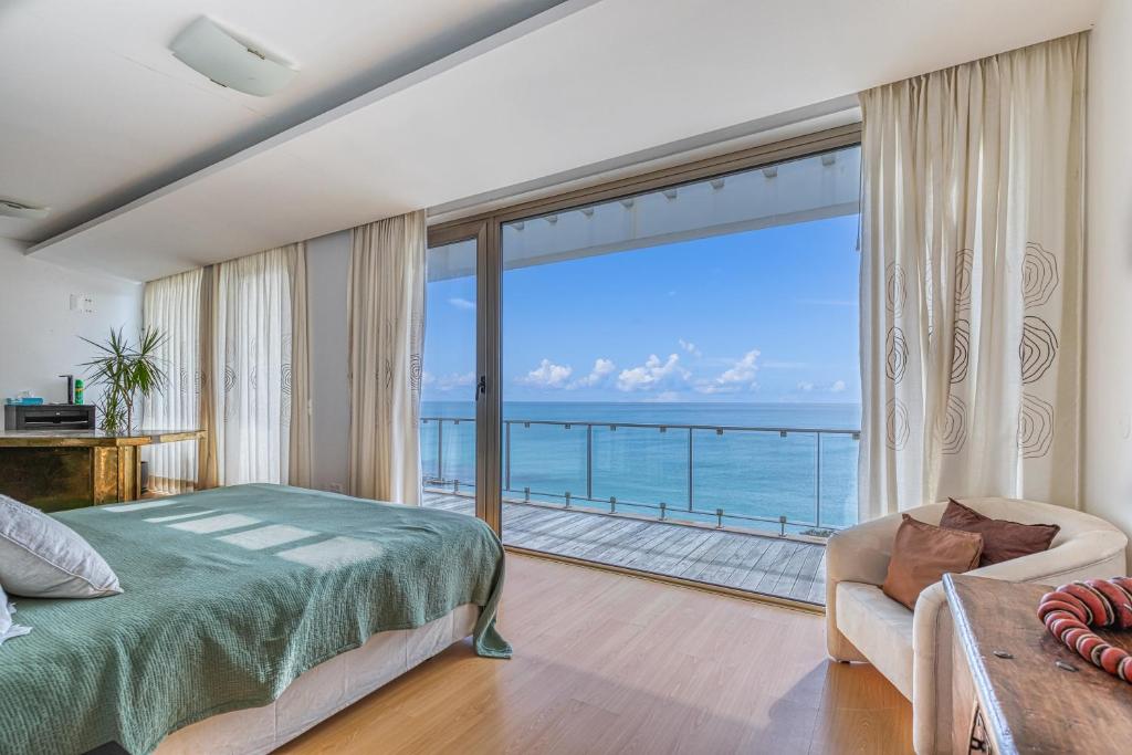 um quarto com uma cama e vista para o oceano em Luz da Lua. Ocean front luxury. Private pool. na Praia da Luz