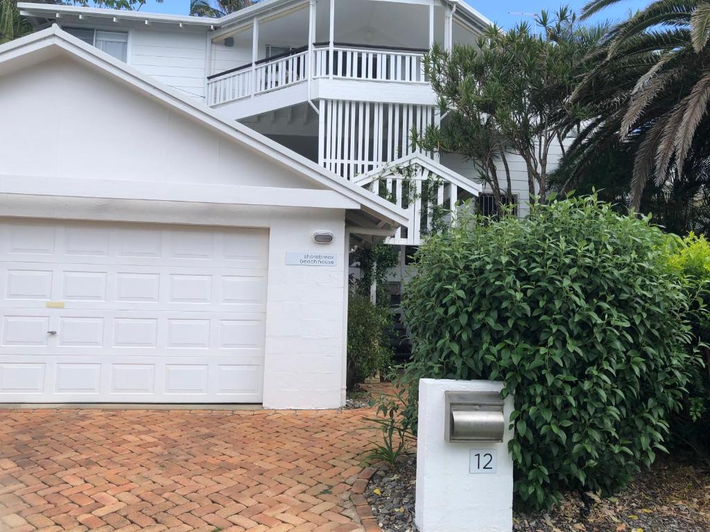 a white house with a garage and a building at Shorebreak Studio Apartments in Sapphire Beach