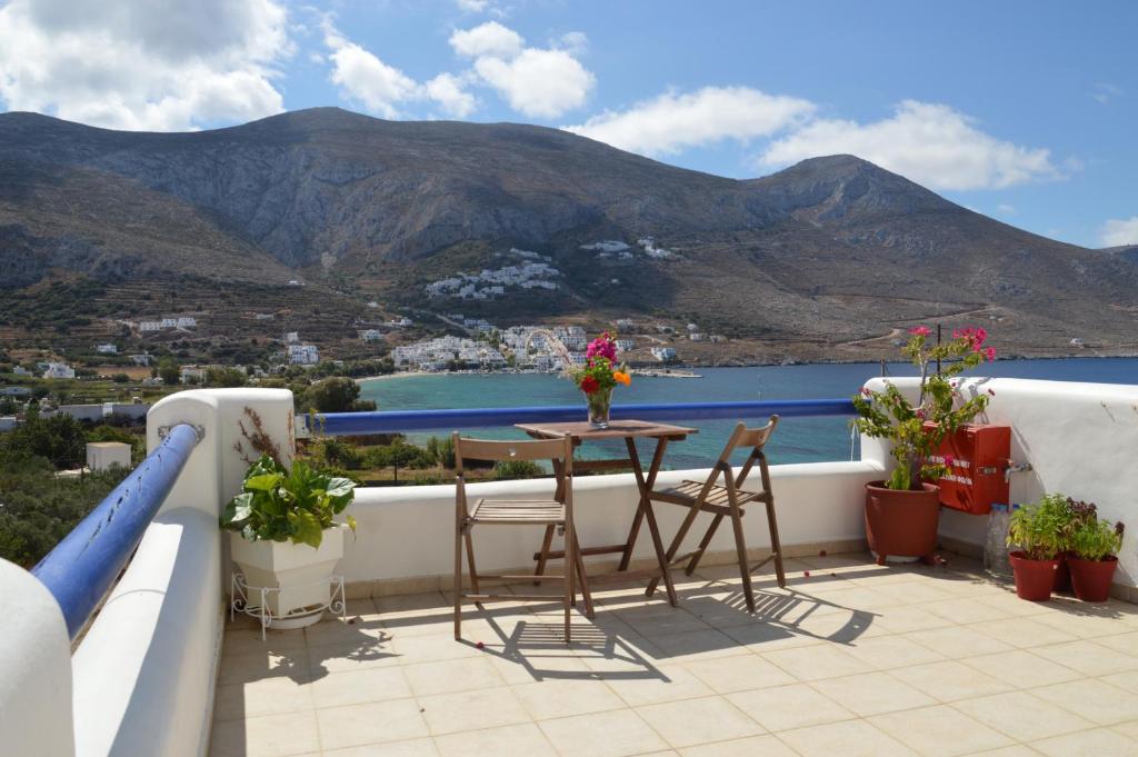 a balcony with a table and chairs and a view at Amorgi Studios in Aegiali