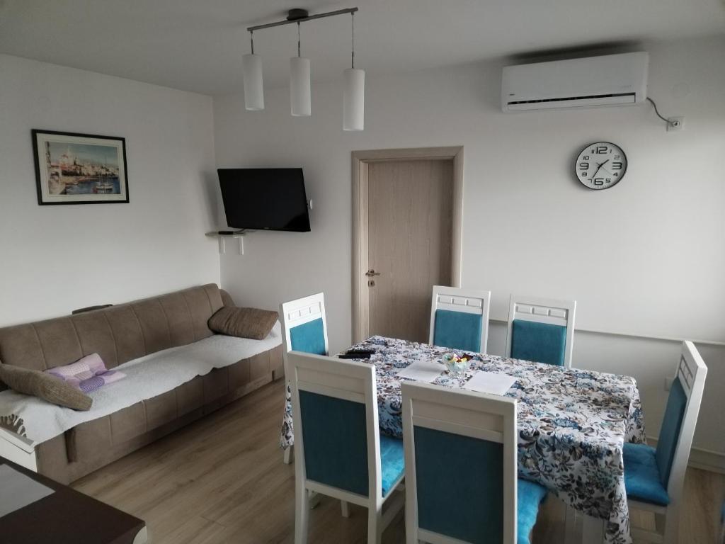 a living room with a table and chairs and a couch at Downtown penthouse Šabac in Šabac