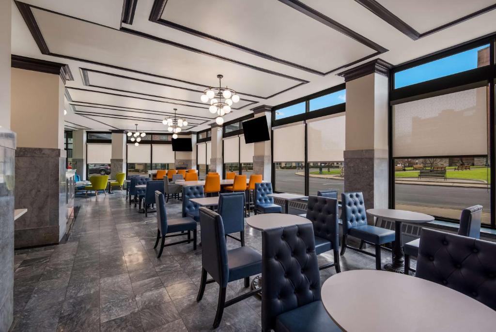 a dining room with tables and chairs and windows at Best Western Syracuse Downtown Hotel and Suites in Syracuse
