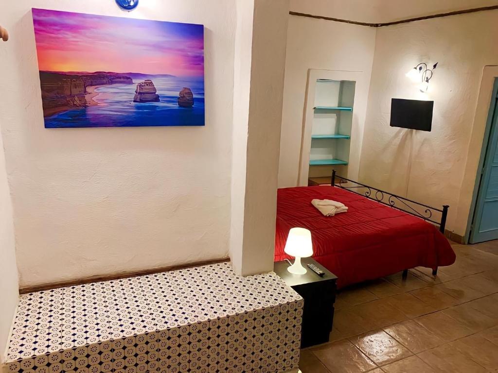 a bedroom with a red bed and a painting on the wall at Central House Catania historic Center in Catania