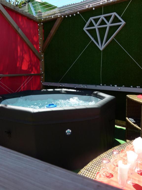 eine Whirlpool-Badewanne mit einem Tisch und Weingläsern in der Unterkunft Ti Mango Julie in Le Gosier