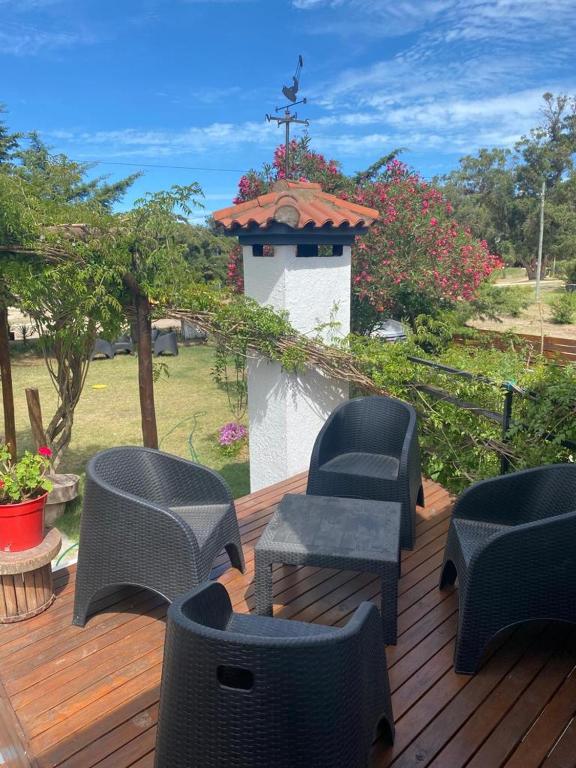 una terraza con sillas de mimbre, una mesa y una cruz en Familia del Viento en Ostende