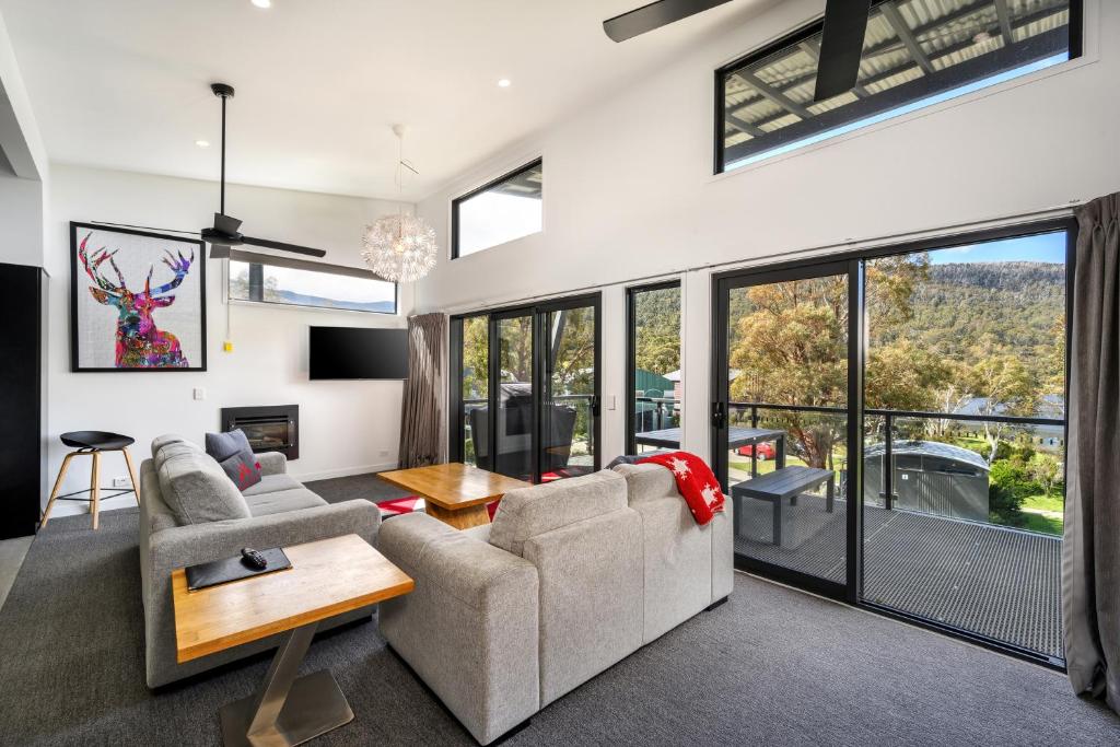 a living room with a couch and a table at Monument Chalet in Crakenback Resort in Crackenback