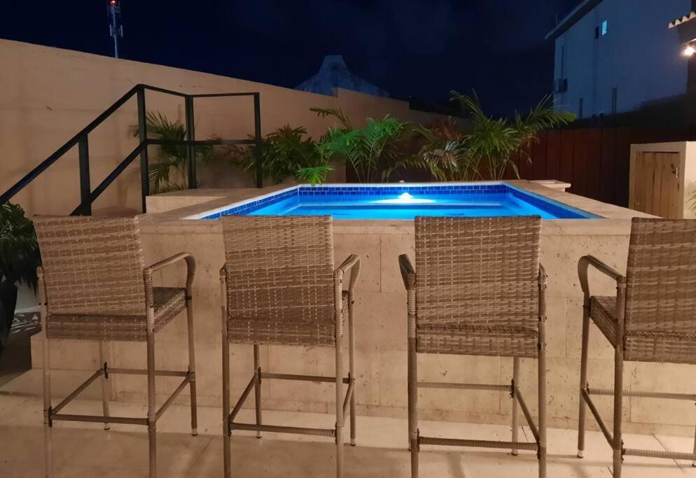 a group of chairs and a swimming pool at Ojanea Home in Palm-Eagle Beach