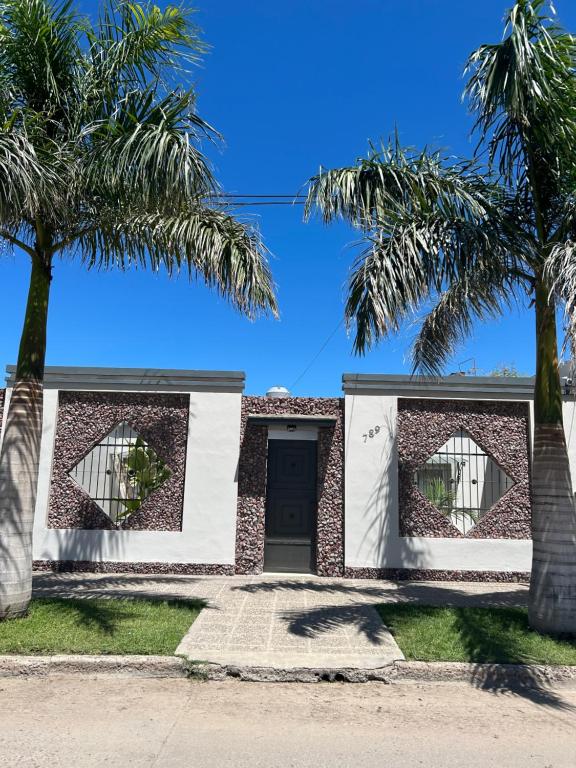 una casa con palmeras delante en Piedra Rosada en Santiago del Estero