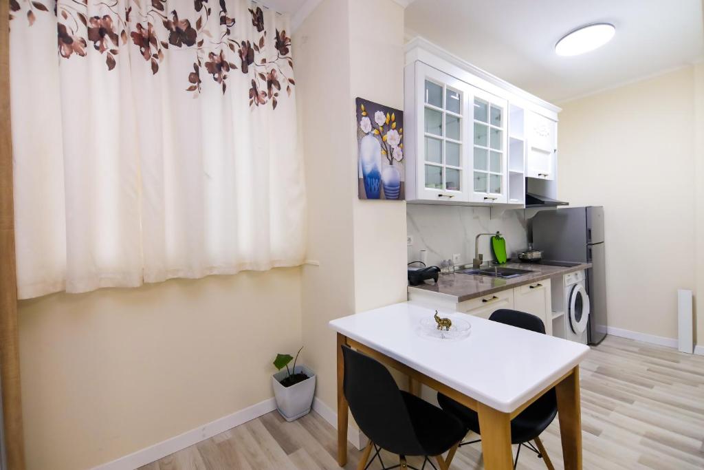 a kitchen with a table and chairs in a room at Nazari Apartment 1 in Tirana