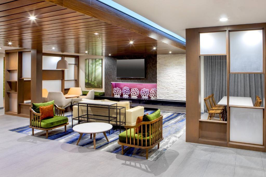 a lobby with chairs and tables and a tv at Fairfield Inn & Suites by Marriott McPherson in McPherson
