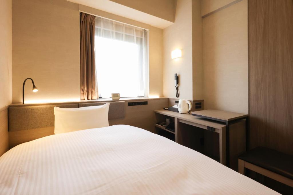 Postel nebo postele na pokoji v ubytování SK HOTEL Kobe Ekimae