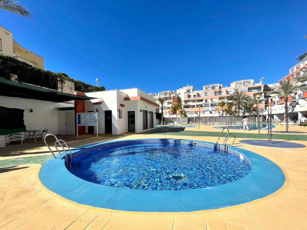 Los Amarguillos的住宿－Lavish apartment in Vera Playa with hot tub，庭院内的大型游泳池,其建筑背景为: