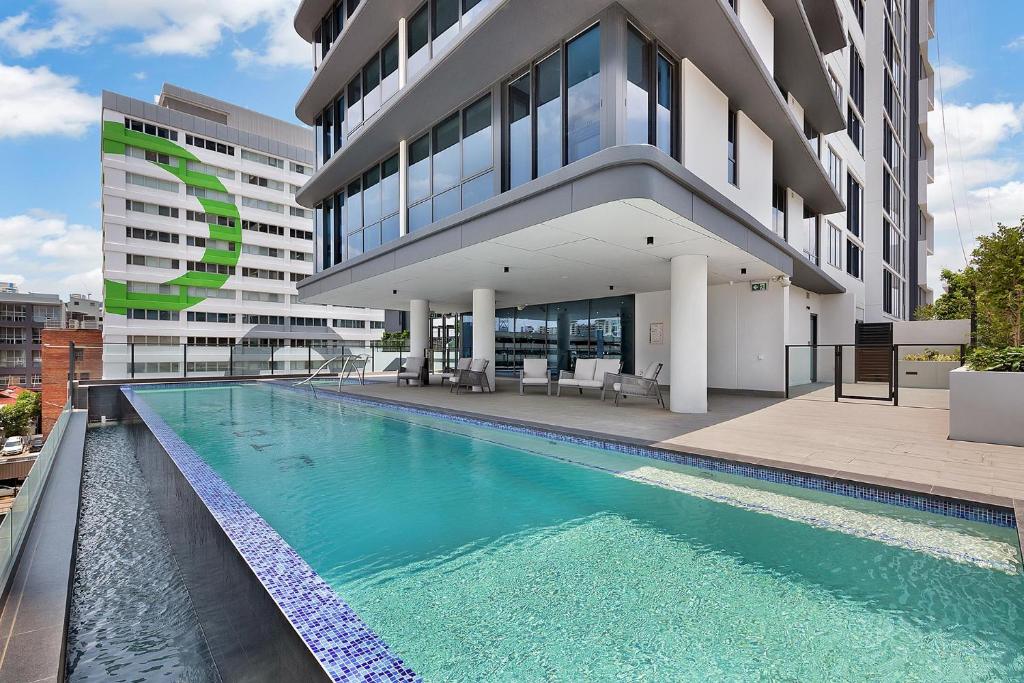 um edifício com piscina em frente a um edifício em Kooii Apartments em Brisbane