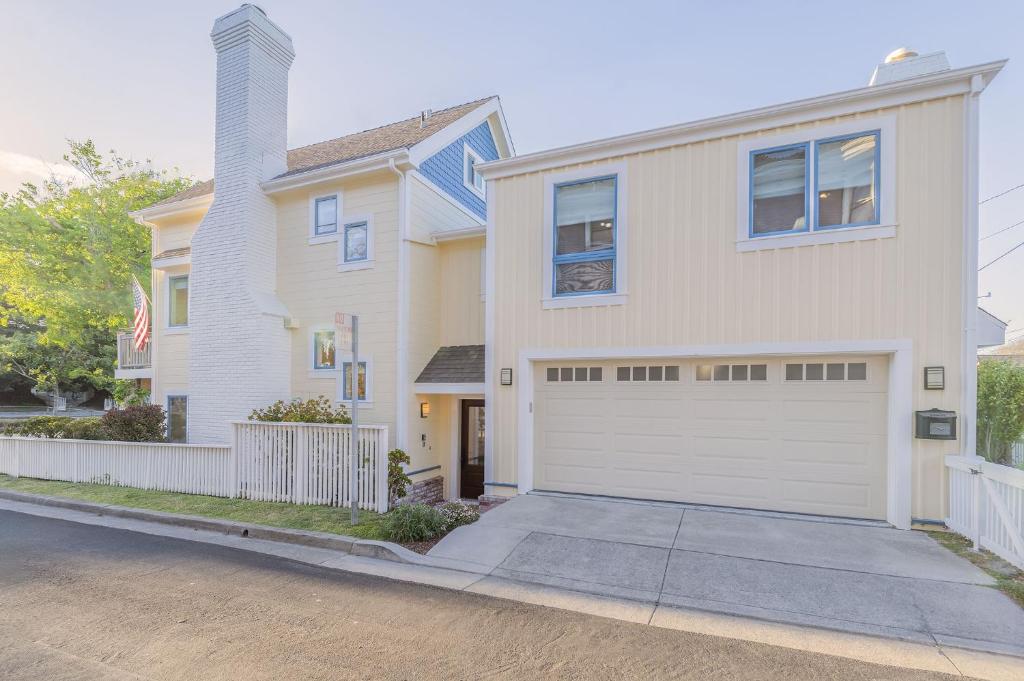 una casa con una puerta de garaje blanca en una calle en 3817 Caledonia Bay Lookout home, en Pacific Grove