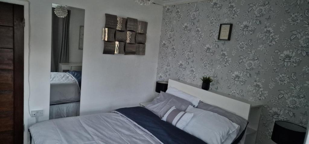 a bedroom with a bed with white sheets and pillows at Pleasant Lodge in Northampton