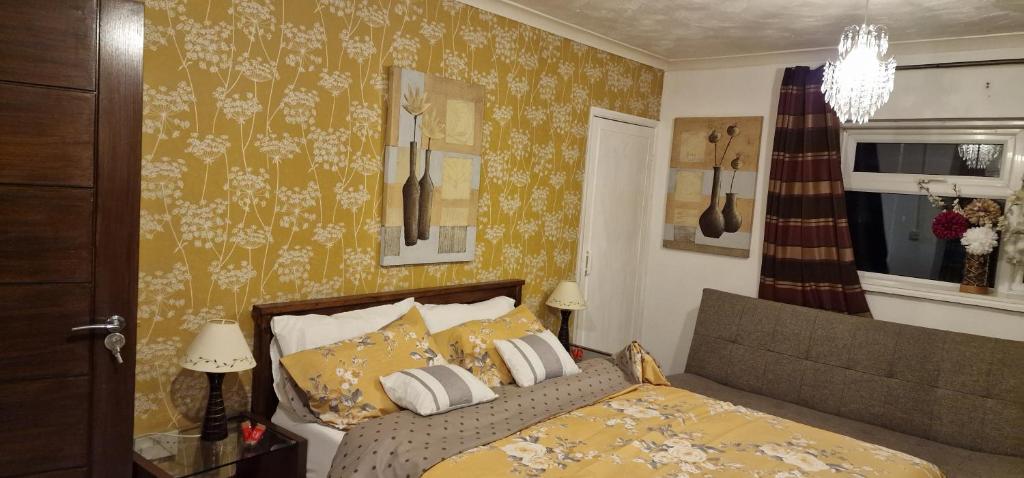 a bedroom with a bed with yellow wallpaper at J Lodge in Northampton