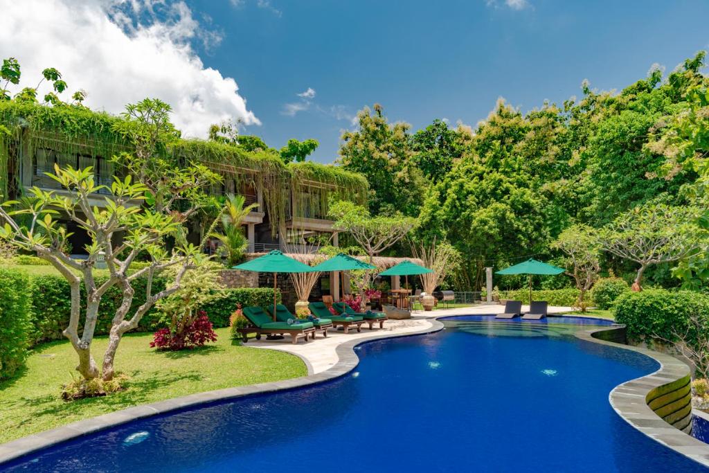 羅威那的住宿－Alamanda Lovina Resort，度假村的游泳池,配有椅子和遮阳伞