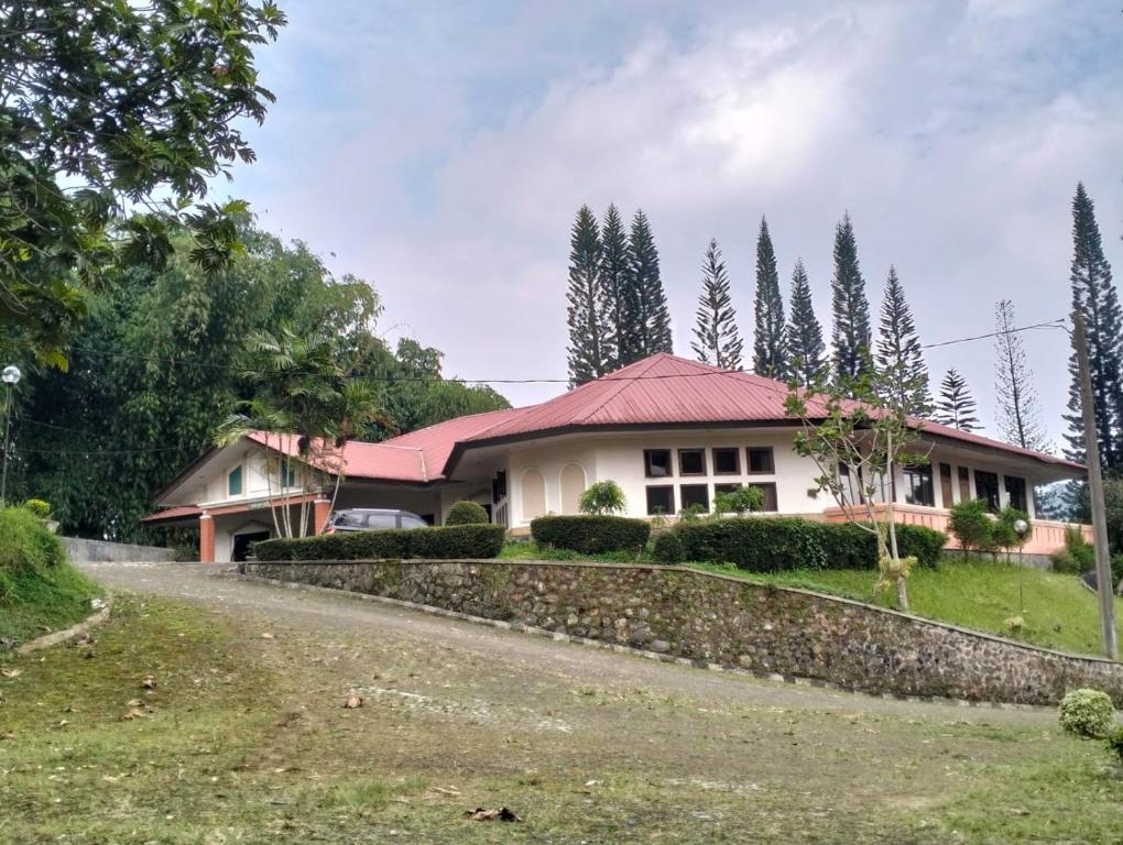 a house with a red roof and a road at Villa Landis Resort in Pacet