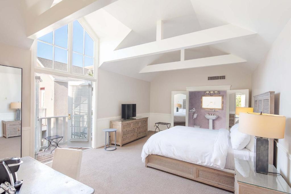 a bedroom with a bed and a desk and a tv at Hotel La Rose in Santa Rosa