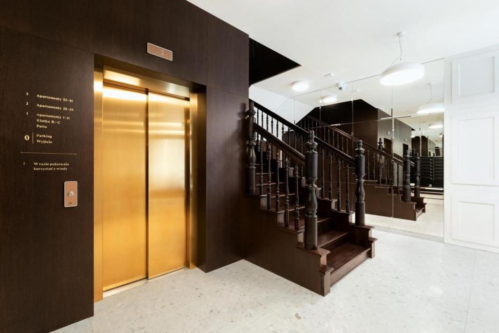 um átrio com elevador e escadas num edifício em Apartament Złota winda Tuwima em Lódź