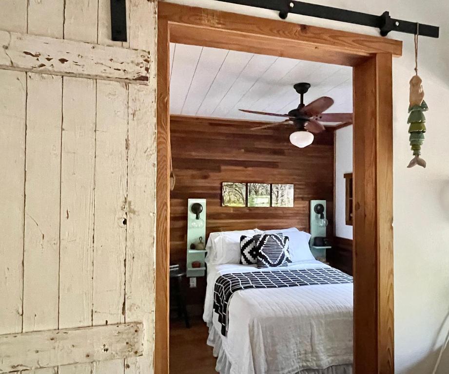 - une chambre avec un lit et un ventilateur de plafond dans l'établissement The Harmony Oaks Homestead, à Masaryktown