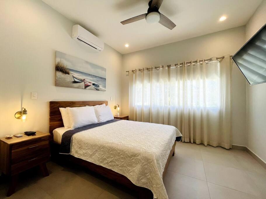 1 dormitorio con 1 cama y ventilador de techo en Casa Lapa Roja, en Playa Hermosa