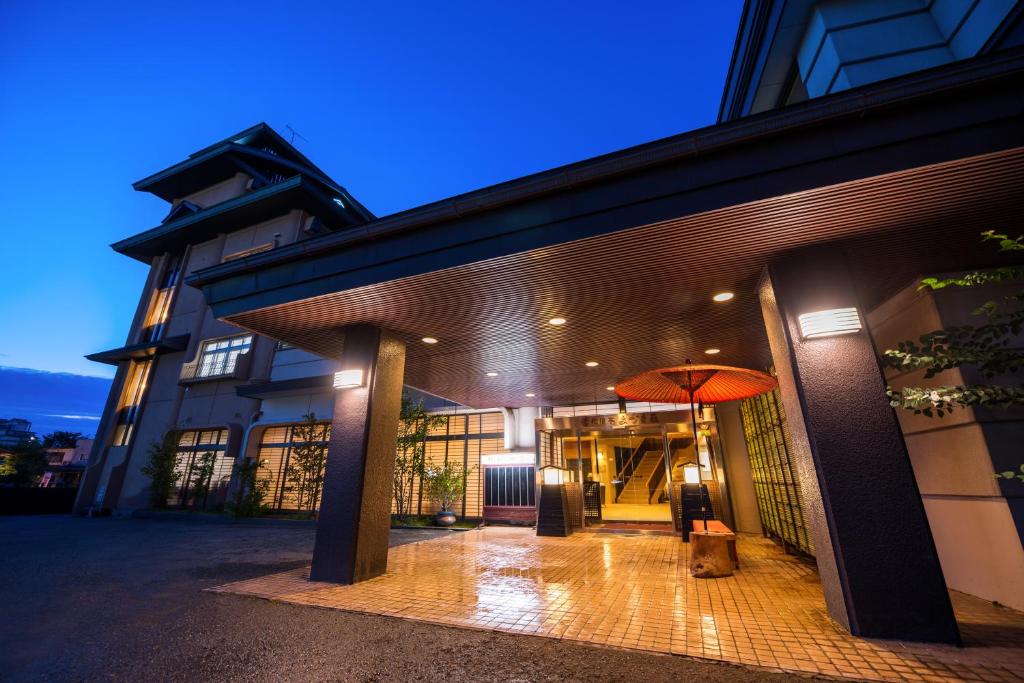 a building with an orange umbrella in front of it at Shouhakutei Azumaso in Tendo